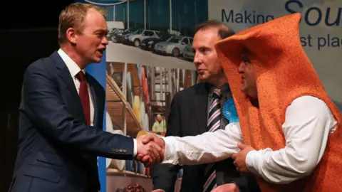 Getty Images Tim Farron shakes hands with Mr Fishfinger at the Westmorland and Lonsdale count on June 9, 2017