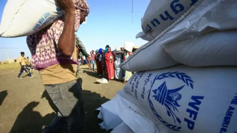 AFP via Getty Images A man carries a World Food Programme sack