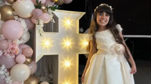 Family handout Alice da Silva Aguair smiles at the camera wearing her white Communion dress