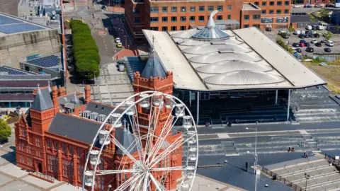 A shot of the Senedd from above, with the Pierhead building and a Ferris wheel in view to the left hand side