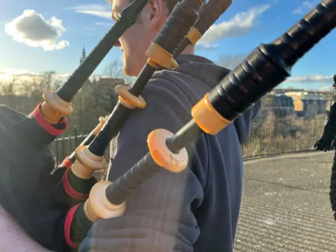 A close up view of the pipes. Alasdair is holding them.