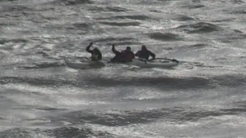 RNLI Four canoeists in a canoe at sea
