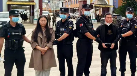 Ming Zhenzhen and Ming Guoping in the custody of Chinese police