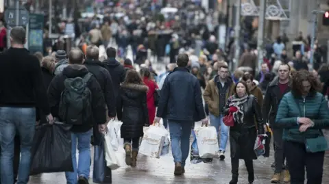 A busy street full of shoppers. 