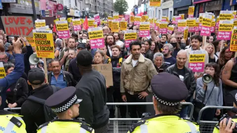 PA Media Protesters and police during an anti-racism demonstration in Walthamstow, London