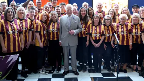 PA King Charles posing with members of the Bantam of the Opera choir, a group of local Bradford City Football Club fans taught to sing