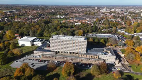 An aerial image of Norfolk County Hall, a large office building in a rectangular shape, surrounded by trees