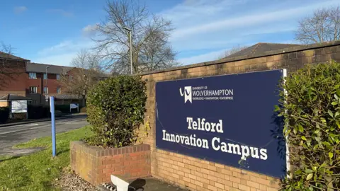 A blue sign on a brick wall which reads university of wolverhampton Telford innovation campus