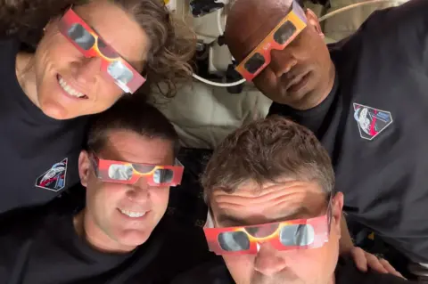 NASA The Artemis II crew – Mission Specialist Christina Koch (top left), Mission Specialist Jeremy Hansen (bottom left), Commander Reid Wiseman (bottom right), and Pilot Victor Glover (top right) – uses eclipse viewers, identical to what NASA produced for the 2023 annular eclipse and 2024 total solar eclipse, to protect their eyes at key moments during the solar eclipse they experienced during their lunar flyby. 