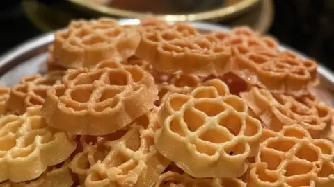 Cathy George Fried rose-shaped cookies- stacked on each other with a little bit of shine on them.