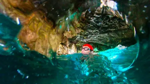 Man swimming through tunnel