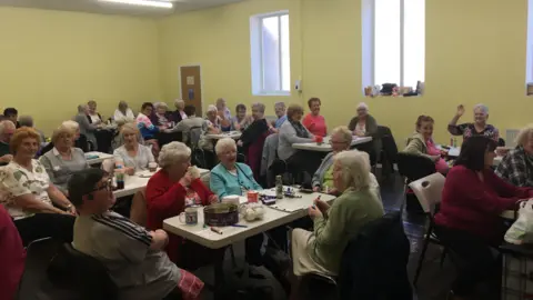 Tuebrook Hope Group Pensioners sit around tables taking part in an activity event at the Tuebrook Hope Group