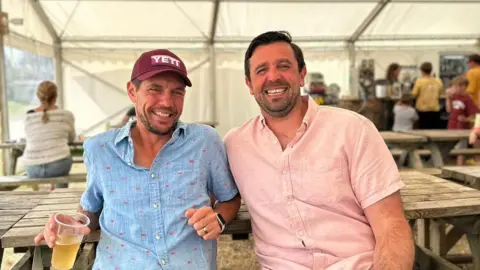 Supplied Two men drinking beer and laughing. 
