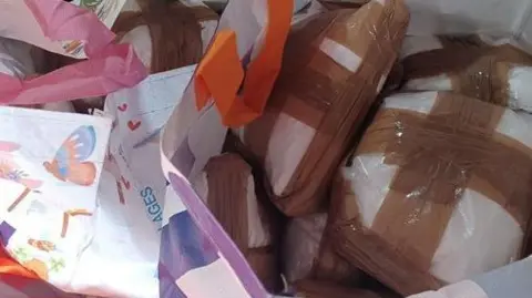 Sealed packages of suspected cocaine in a carrier bags.