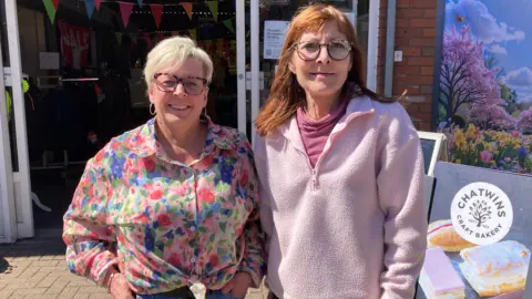 A view of Julie Hodkinson and Julie Allen outside Winsford Market in Cheshire on a sunny day.