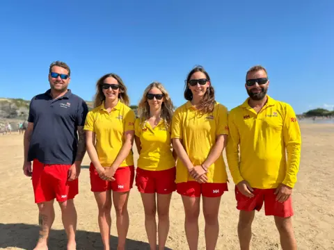 BBC From left to right: Leon Bennett (lifeguard supervisor), Issey, Scarlet, Maisie and Gareth Barnes