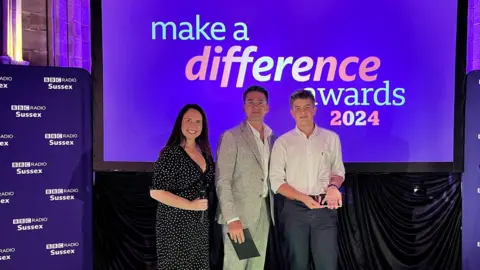 A woman, a man and a teenager are at the 2024 BBC Make A Difference Awards presentation.