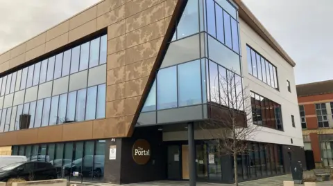 Outside shot of the Portal building in Chester, which houses some council services. It's a modern building with striking gold-coloured features on the outside.