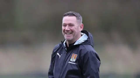 Kevin Nolan smiling wearing a Northampton Town jacket