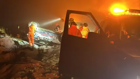 Hollie McRae A recovery crew attending to the rally car in the dark