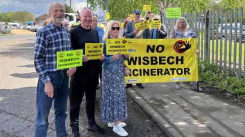 Protesters with signs saying No Wisbech Incinerator on Algores Way in Wisbech
