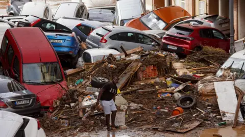 Getty Images The debris in the streets of Valencia after cars were pushed through flooded water