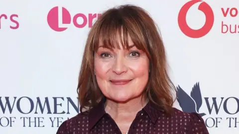 Getty Images Lorraine Kelly poses against a backdrop for a 2024 awards ceremony