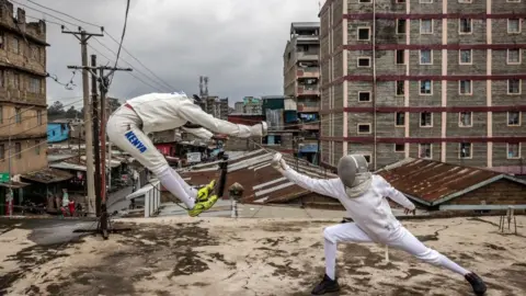 Luis Tato/AFP Two Kenyans wearing white fencing gear fight in the streets of Nairobi 9 June