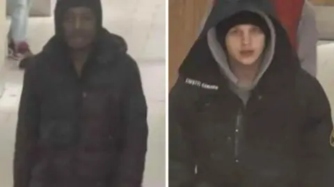 Nottinghamshire Police Two CCTV images side-by-side of two men police wish to speak to. The man on the left is black and is wearing dark clothing, with his hood up. The man on the right is white and is wearing a black coat, black hat and grey hoody, with his hoods up. They both look young