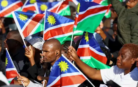 Siphiwe Sibeko / Reuters Mourners hold Namibian flags during the burial of Sam Nujoma, who became Namibia's first democratically elected president, at Namibia's Heroes' Acre, near the capital Windhoek.