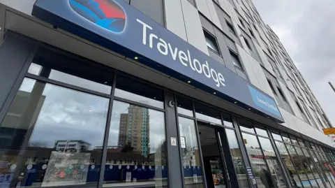 Outside of Travelodge London Straford hotel. It looks like a block of flats with branding on the first floor