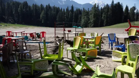 Reuters Green, blue and red chairs along with tables are scattered in a meadow after a militant attack on tourists in Baisaran near Pahalgam