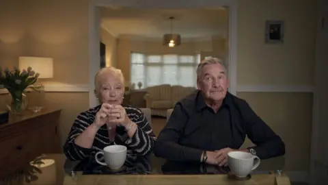 Nicola's mother and father sitting and a table while being interviewed for the BBC's documentary 