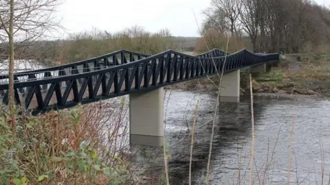 Preston City Council Artist impression of the new bridge, spanning the river and consisting of two concrete posts supported by black steel work with V-shaped trusses and a scalloped rail