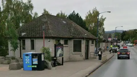 The toilets are on a side of Grampian Road in Aviemore. It is a block-type building with a peaked roof. 