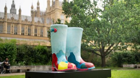 A large sculpture of wellington boots outside the houses of parliament