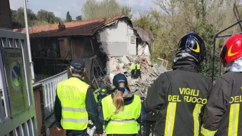 Polizia Roma Capitale Police and fire officers look at the remains of the apartment building after the explosion.