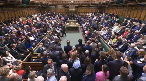 HoC via PA Media A wide view shows the House of Commons packed full of MPs as the Bill is passed in June.