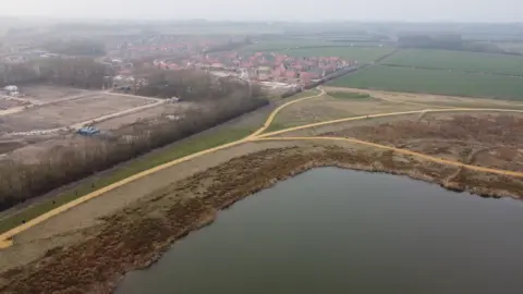 BBC An aerial shot of the new houses near the lake and park