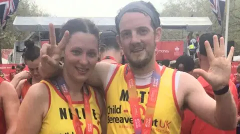 Supplied A man and a woman wearing yellow running shirts, with the label Child Bereavement UK, printed on the clothing. They each have a medal around their necks.