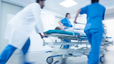 Doctors pushing patient on a trolley