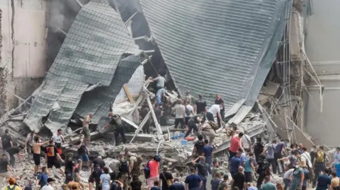 Rescue workers at the damaged hospital, Reuters