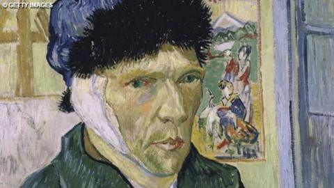 Image is Van Gogh's Self-portrait with bandaged ear.  He is wearing a hat, the bandage is visible over his right ear.  He is wearing a green top, hit hat is black and blue.  Behind him is an easel with a canvas on it and a picture is on the wall behind him showing some figures outside.  Part of a door frame is visible on the right hand side.