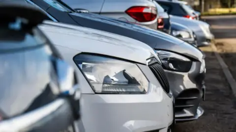 A fleet of cars parked in a car park. 