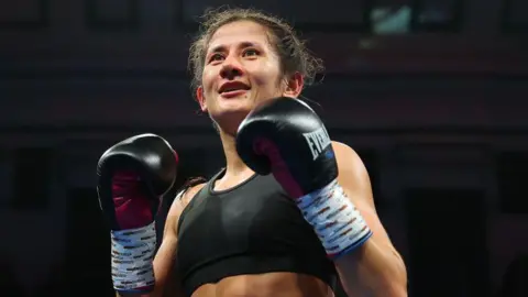 Nina Hughes in black gloves in the ring