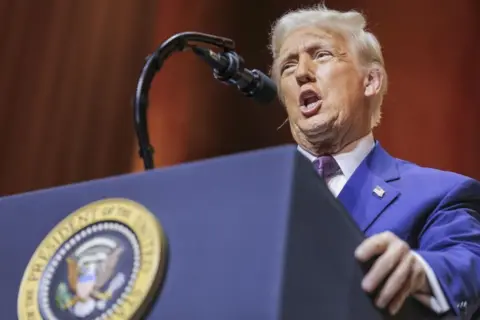 EEP US President Donal Trump Addresses Republican Governors Association Meeting in Washington DC on 20 Feb 2025. He is wearing a blue suit and speaking in front of a microphone