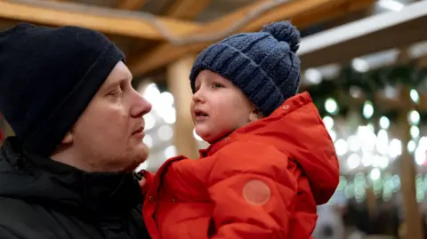 Getty Images A stock image of a father calming a crying chld. Both are dressed in outdoor winter clothes