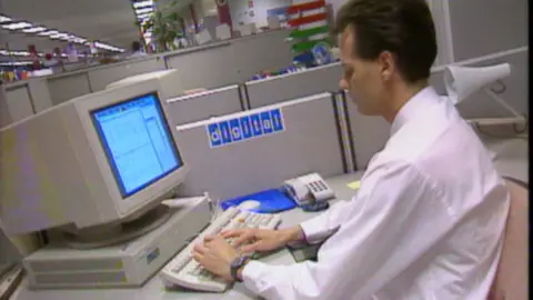 A man works at a desk-top computer in the offices of DEC or digital as they were known to the public.