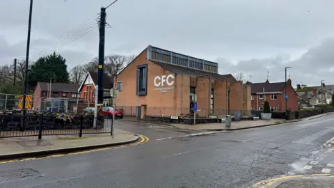 An image of a brick building this is occupied by a church, just behind the building you can see the Royal British Legion club