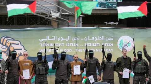 Reuters Mortgage or Levi, Eli Shabi and Ohad Ben Ami are paraded by Hamas fighters in Dare al-Balah, before their release (8 February 2025)